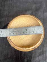 Wooden bowl with a ruler on a dark fabric background